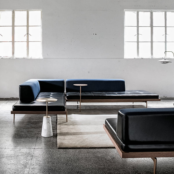 Modern black and blue sectional sofa with minimalist design, featuring sleek lines and contrasting textures.