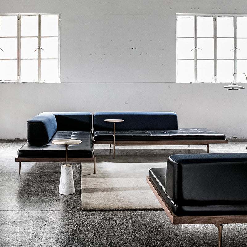 Modern black and blue sectional sofa with minimalist design, featuring sleek lines and contrasting textures.