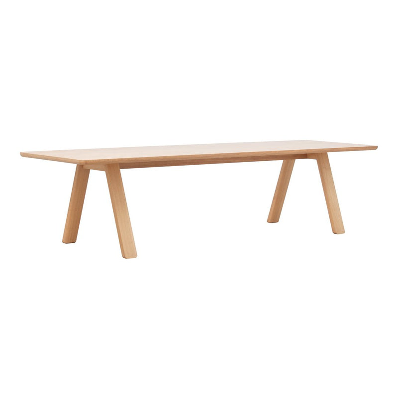 Light wood dining table with a smooth surface and minimalist design, featuring natural grain patterns and a sleek, neutral finish.