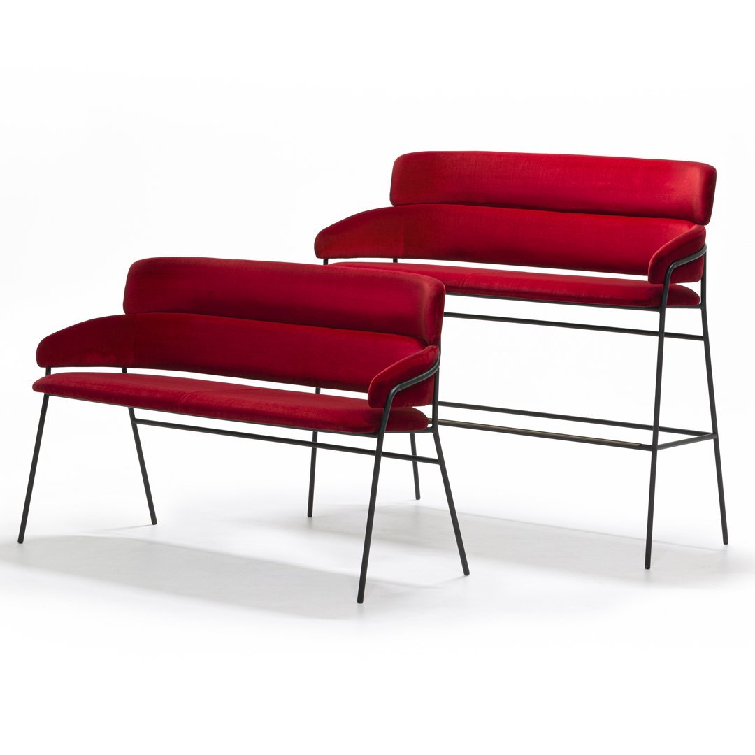 "Set of two modern benches in deep red velvet upholstery with sleek black metal legs."