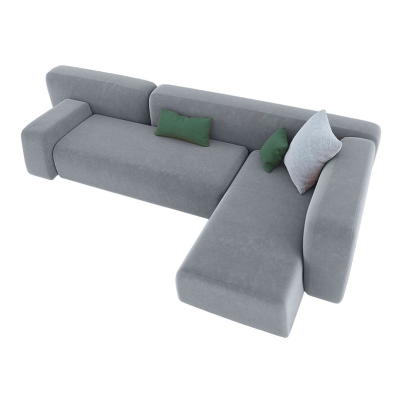 Gray sectional couch with smooth fabric, featuring green and white accent pillows for added color contrast.