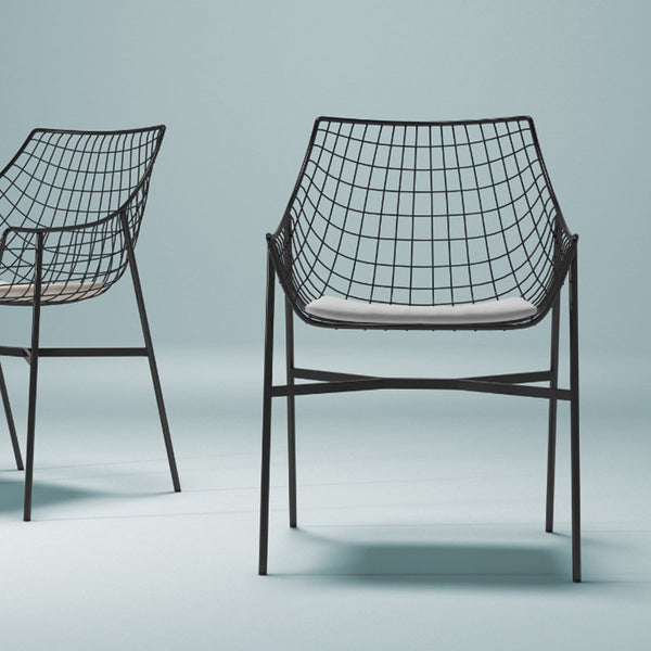 Black wireframe chairs with a grid pattern and light gray cushions against a soft blue background.