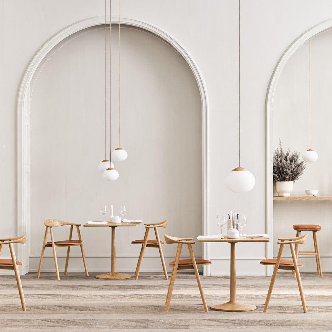 "Modern dining space showcasing neutral walls, wooden furniture, and soft round pendant lighting."