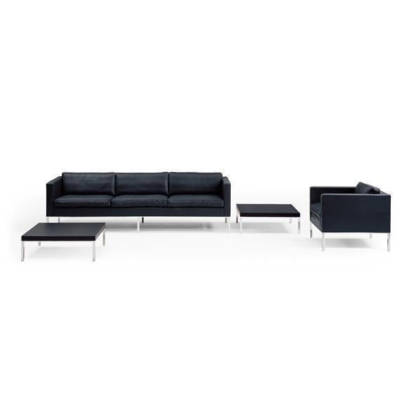 Modern black sofa set with sleek lines and chrome legs, featuring a minimalist design and solid color pattern.