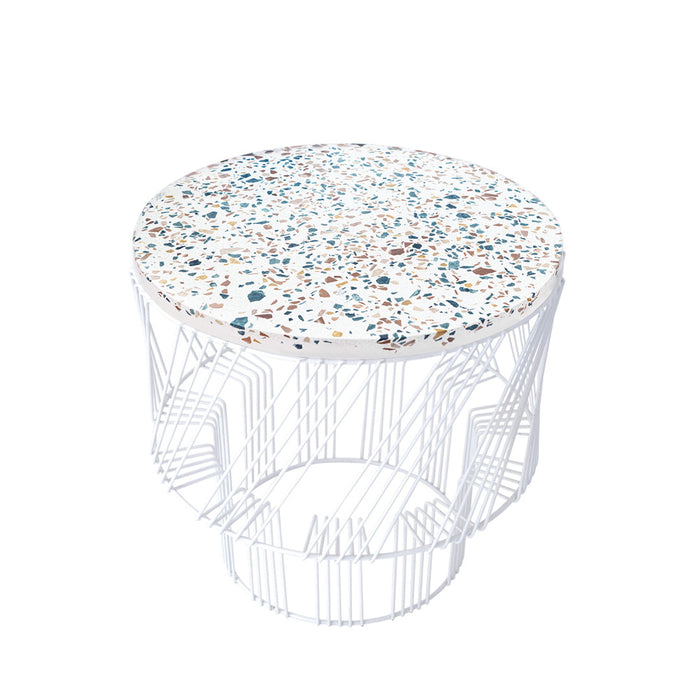 Round white wire table with a speckled top featuring blue, brown, and beige tones. Stylish, modern design.