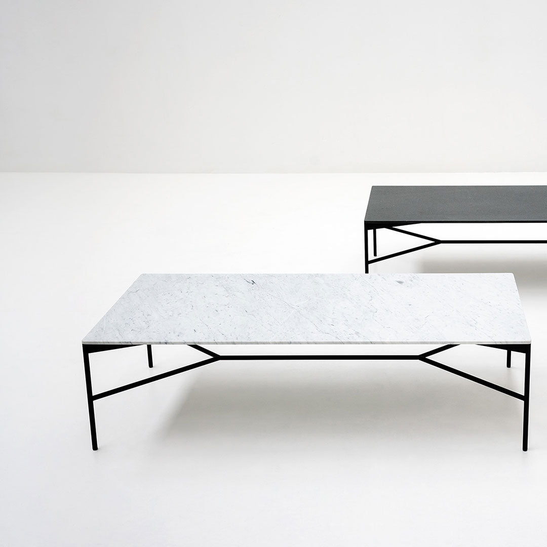 Stylish coffee tables featuring a white patterned marble top and a sleek matte black surface, framed with black metal legs.