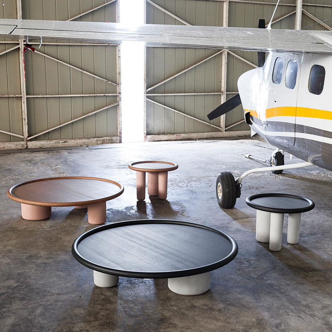 "Modern round coffee tables in black, beige, and pastel hues with minimalist designs and unique pedestal bases."