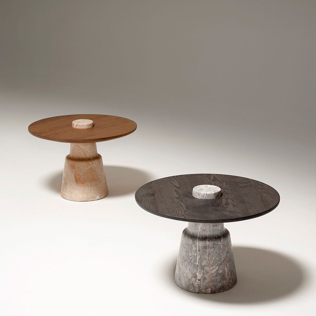 Two modern side tables: one with a brown wooden top and light base, the other with a dark top and textured gray base.