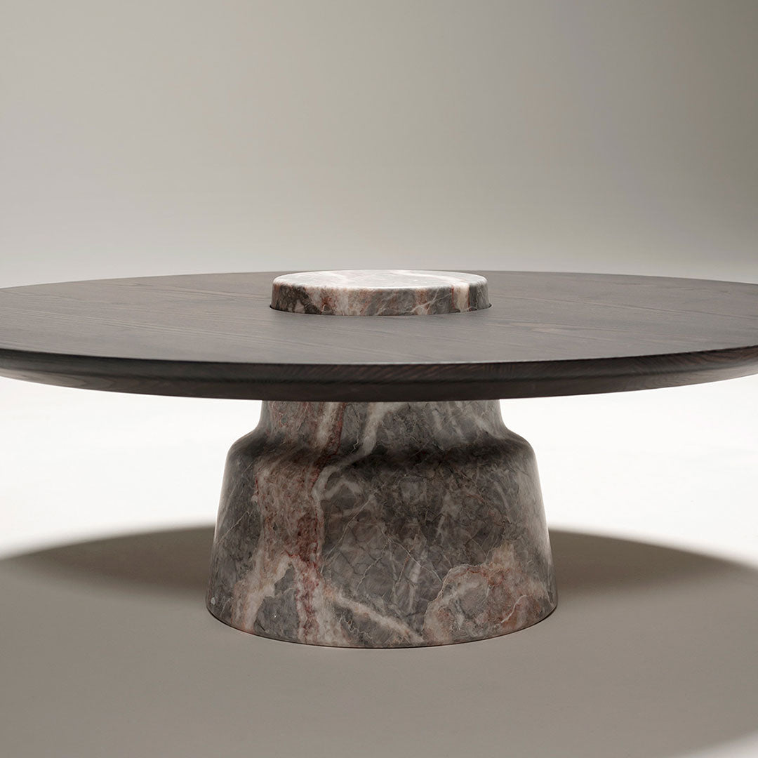 Round marble table featuring a dark gray top with subtle veining and a unique marbled base in earthy tones.