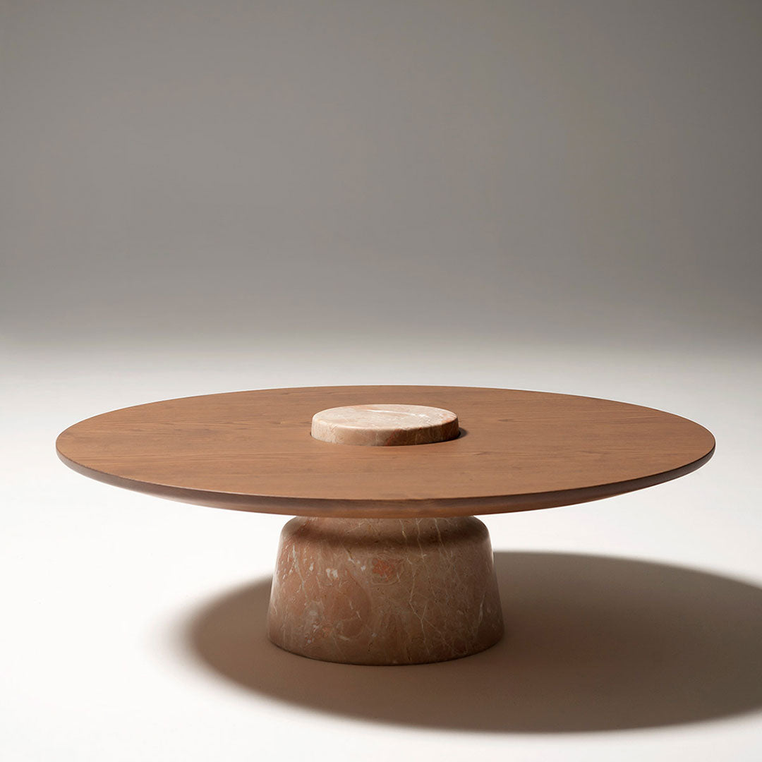 Round wooden coffee table with a smooth light brown top and a textured beige base, featuring minimalist design.