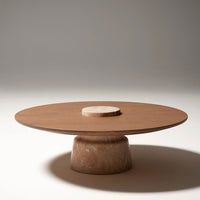 Round wooden coffee table with a smooth light brown top and a textured beige base, featuring minimalist design.