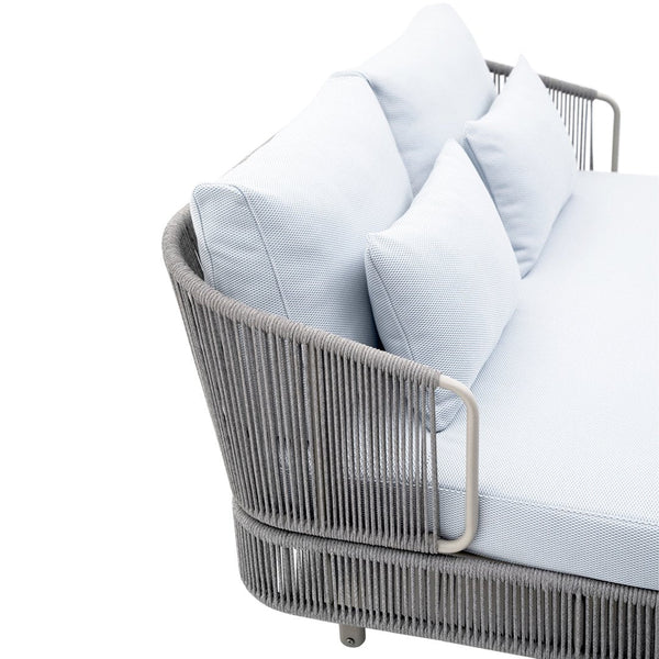 Light blue cushion and seat on modern gray wicker sofa with sleek lines and minimalist design. Perfect for outdoor decor.