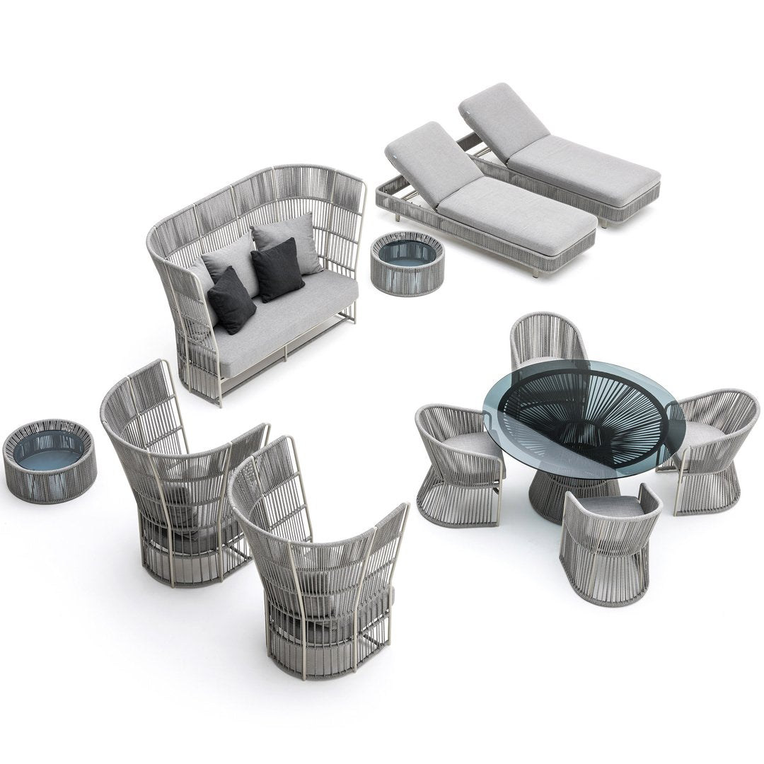 Gray wicker outdoor furniture set with sleek, modern lines and soft gray cushions, featuring a glass-top table and accent pieces.