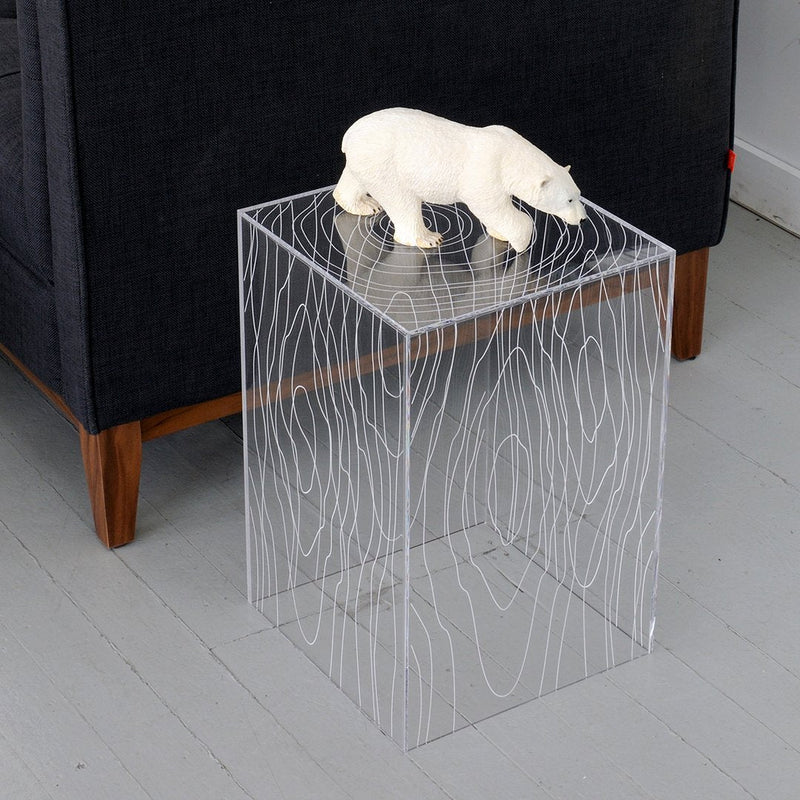 Clear acrylic side table featuring white wave patterns, ideal for modern decor and stylish accents.