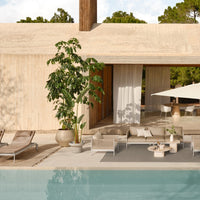 "Modern outdoor living space with neutral tones, green foliage, and gentle textures by the poolside."