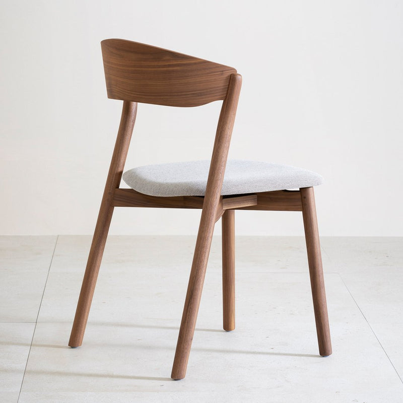 Warm walnut wood chair with a light gray upholstery seat and a minimalist design, enhancing modern interior aesthetics.