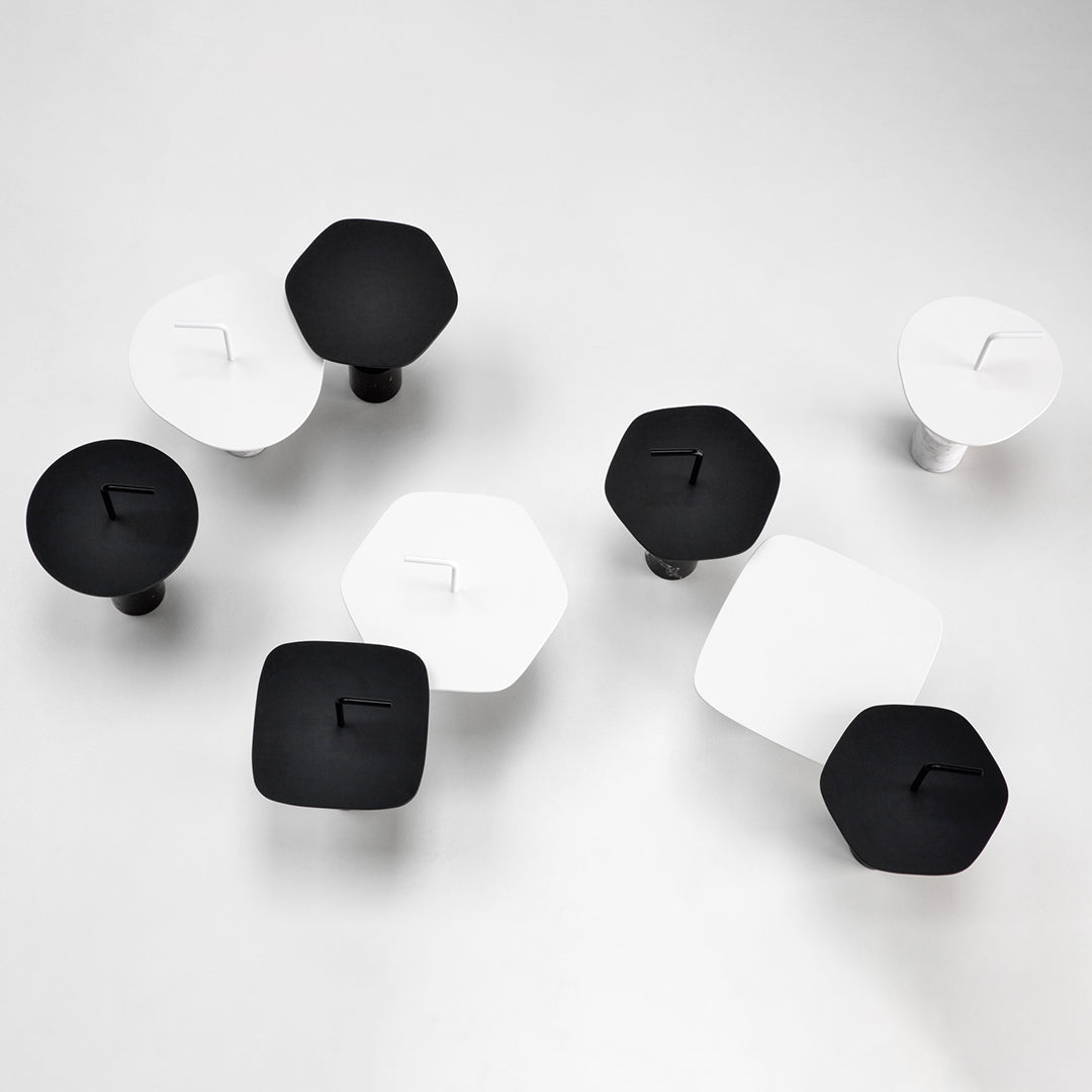 Black and white geometric knobs in varied shapes, arranged in a modern pattern on a light background.