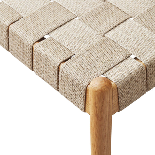 Beige woven fabric with intricate patterns, featuring a seamless, textured design and natural wood accents.