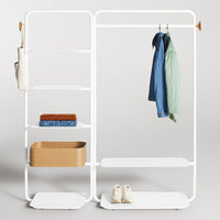 White metal rack with shelves; features natural wood accents and a minimalist design. Holds assorted clothing and accessories.