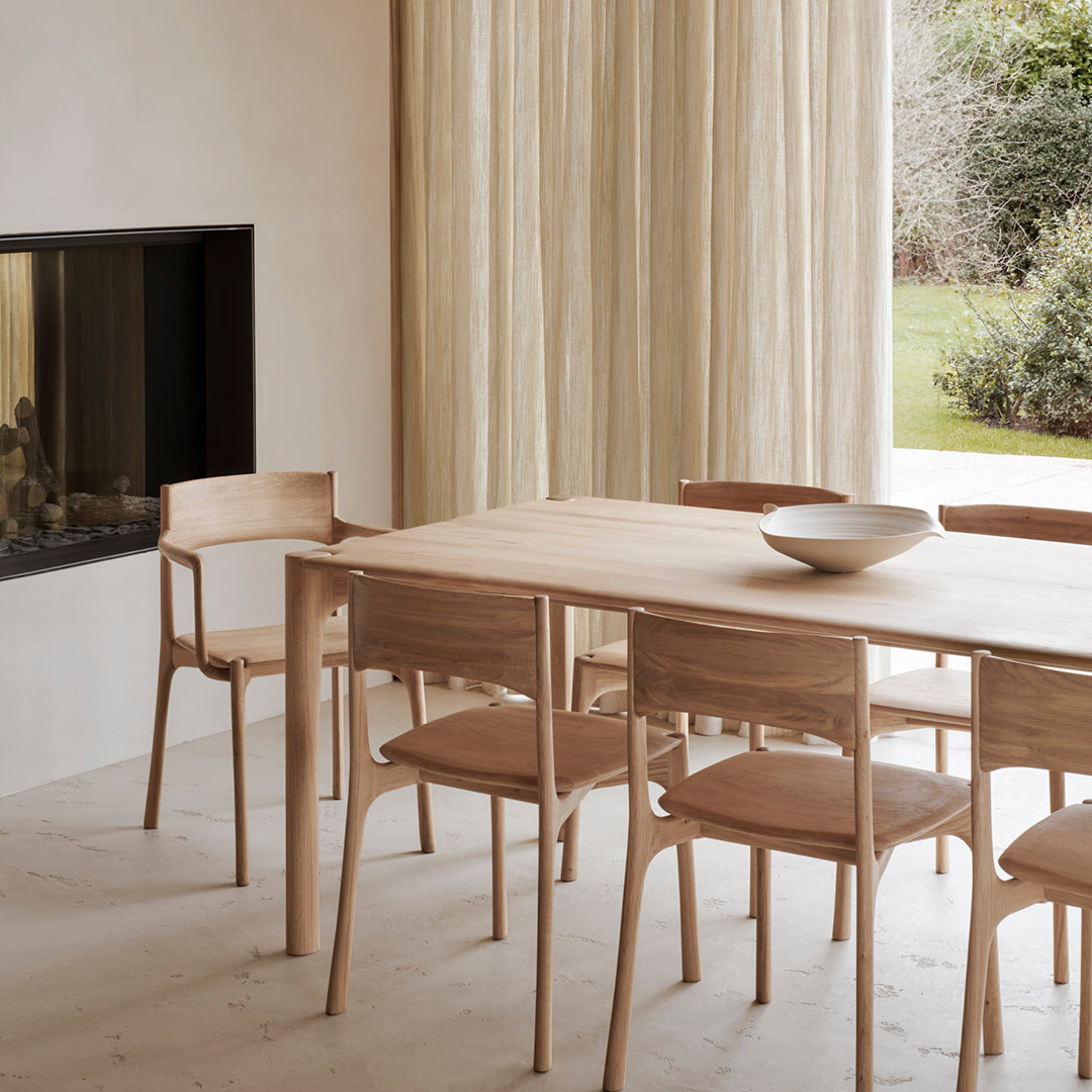 Light wood dining table with beige chairs; soft, neutral colors and minimalistic design create a cozy atmosphere.