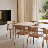 Light wood dining table with beige chairs; soft, neutral colors and minimalistic design create a cozy atmosphere.
