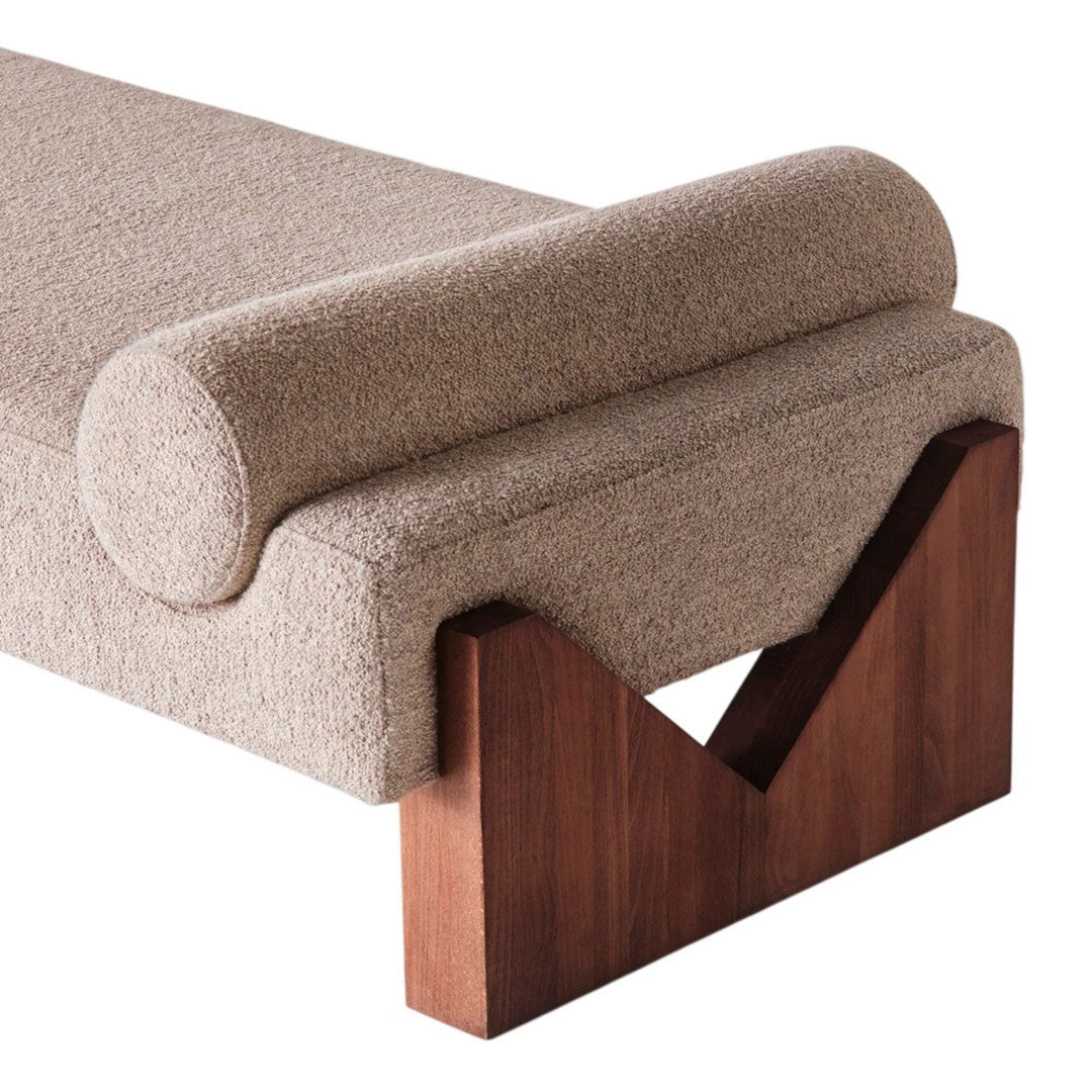 Beige textured upholstery with a rounded bolster, featuring a contrasting dark wood base in a modern geometric design.