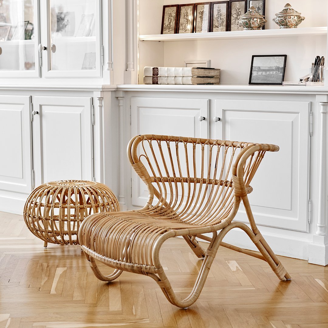 Natural rattan chair and ottoman with a warm, textured finish, showcasing a stylish woven pattern against a light background.
