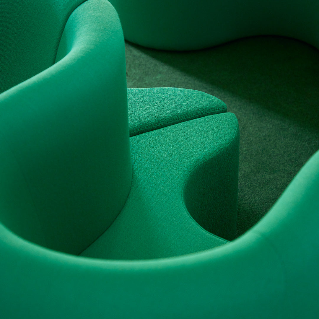 Vibrant green curvy seating in textured fabric, featuring smooth lines and organic shapes for a modern aesthetic.