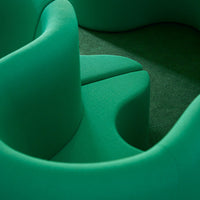 Vibrant green curvy seating in textured fabric, featuring smooth lines and organic shapes for a modern aesthetic.