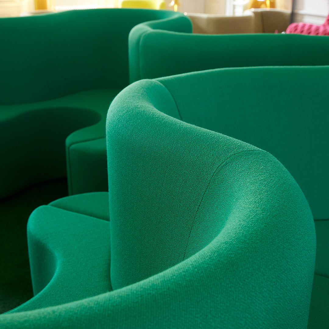 Green textured sofa with curved shapes, featuring a vibrant, modern design perfect for contemporary interiors.