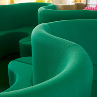 Green textured sofa with curved shapes, featuring a vibrant, modern design perfect for contemporary interiors.