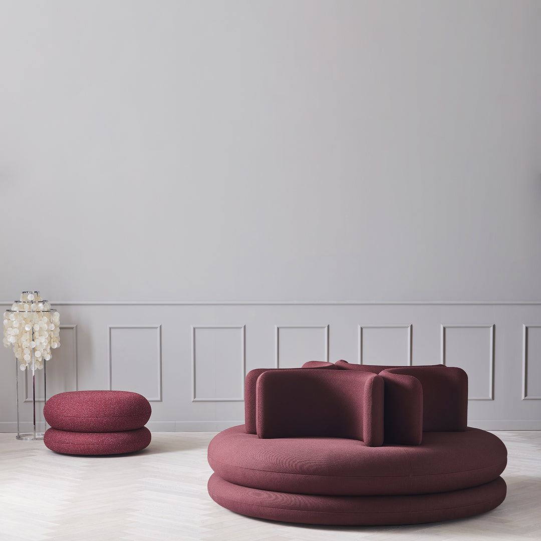 Modern maroon seating set with rounded shapes and textured fabric against a light grey backdrop.