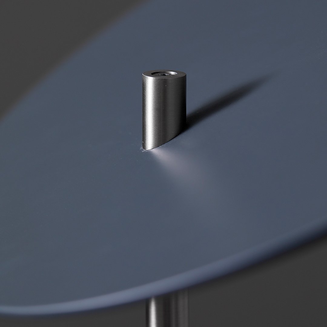 Close-up of smooth blue surface with a metallic silver peg, showcasing a sleek modern design.