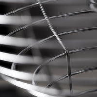 Close-up of shiny silver metal wire basket with smooth, curved lines and an intricate pattern. Perfect for modern decor.