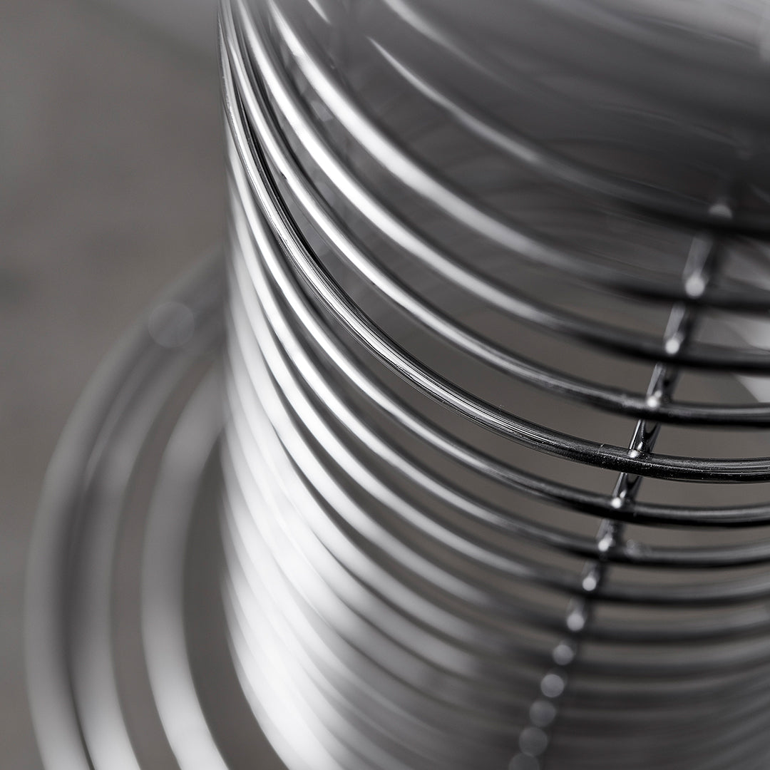 Shiny silver metal coils arranged in a spiral pattern, showcasing a sleek and modern design.