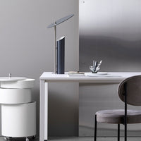 Sleek gray and white office setting featuring a minimalist design with subtle metallic accents and a modern lamp.