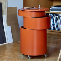 Orange cylindrical storage unit with layered design and a glossy finish, perfect for modern interiors.