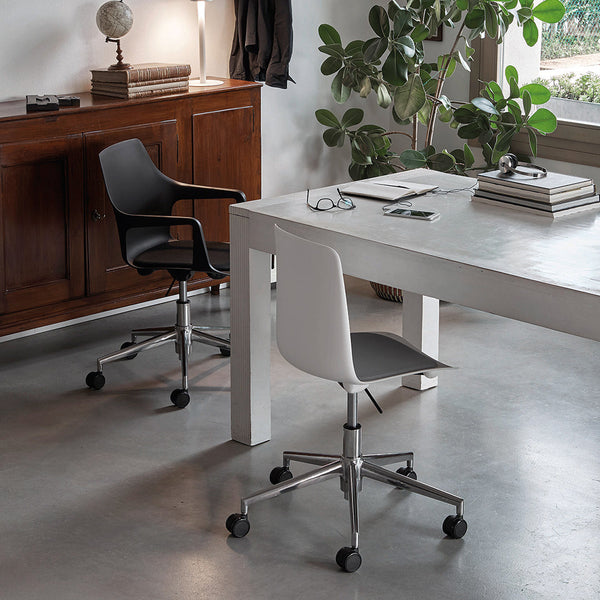 Modern office space featuring a black and white chair with sleek lines, set against a minimalist white table.