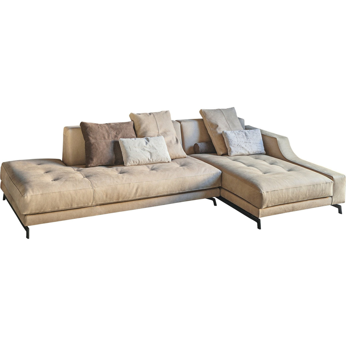 Beige upholstered sectional sofa with tufted cushions and decorative gray pillows on a sleek black metal base.