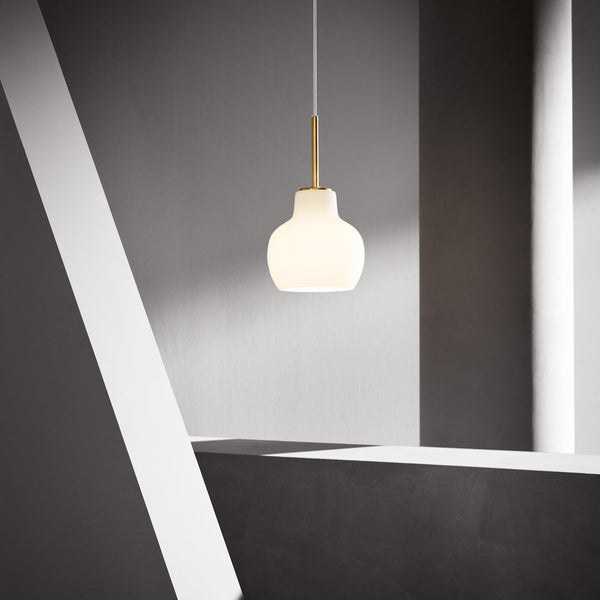 Sleek white pendant lamp with a golden accent, set against a minimalist gray backdrop with geometric shapes.