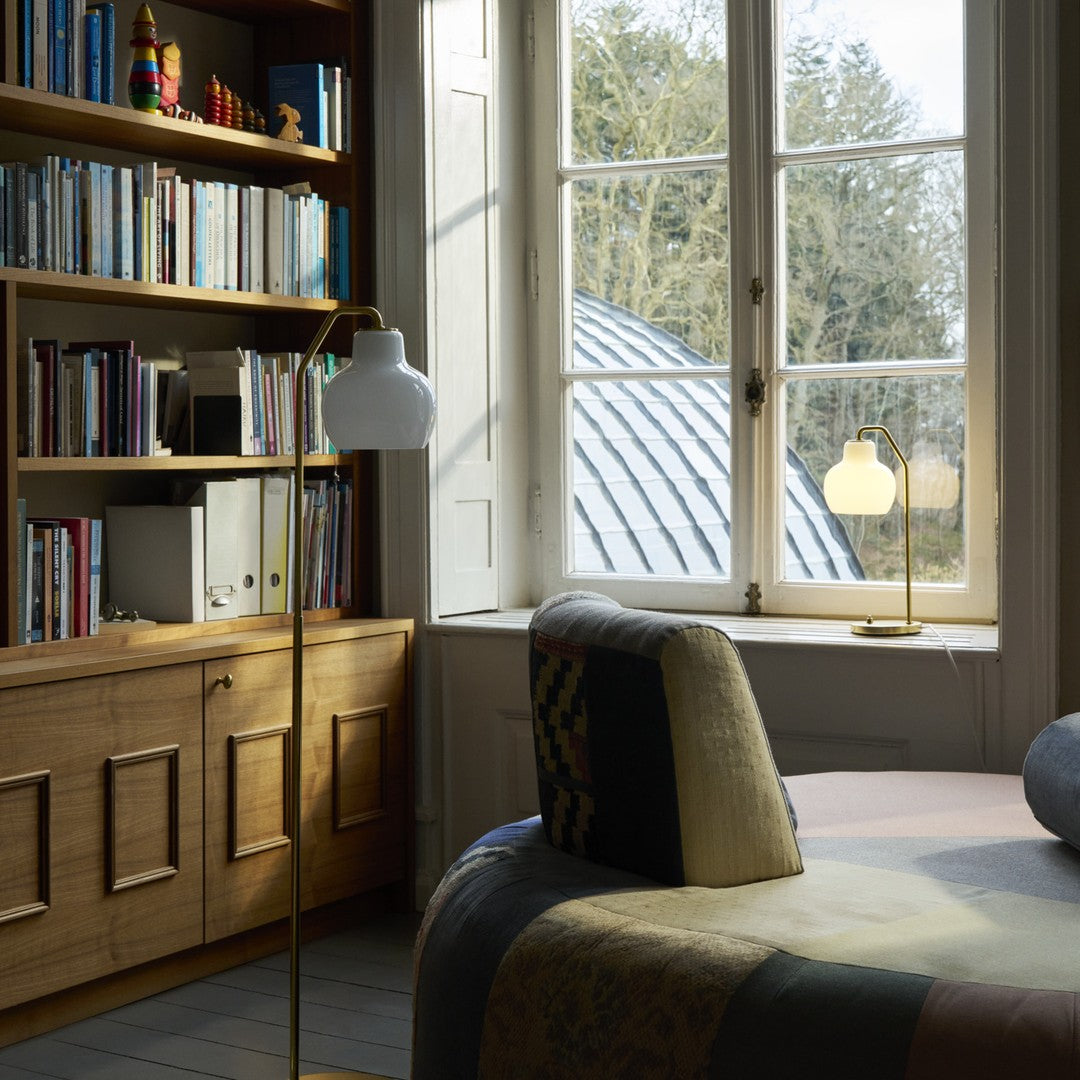 Room interior with wooden bookshelf, chair, and large window.