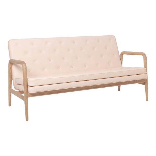 Light pink tufted fabric sofa with natural wood frame and minimalist design. Perfect for modern interiors.