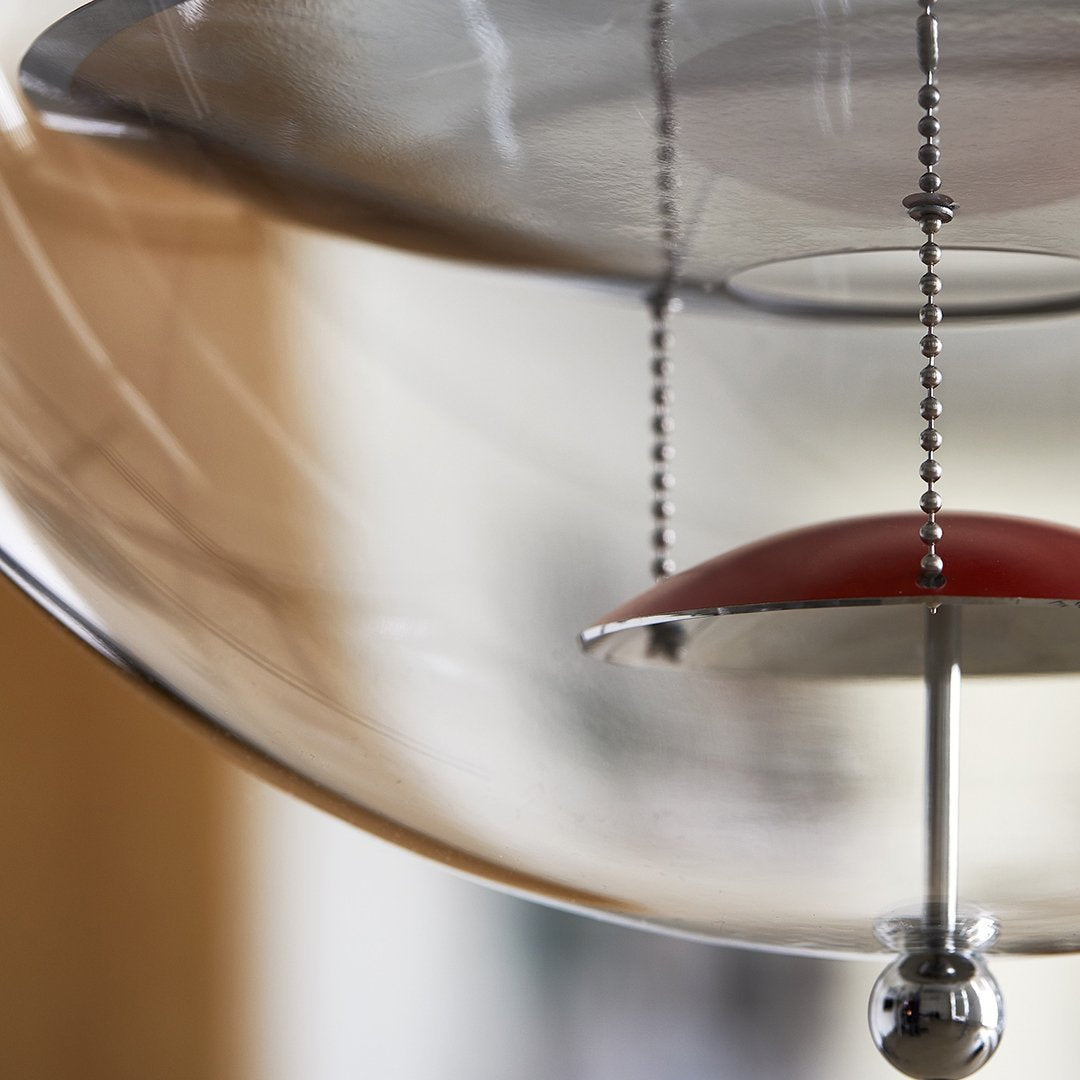 Modern pendant lamp with a clear glass shade, red accent, and sleek chrome details, creating a stylish and minimalistic look.