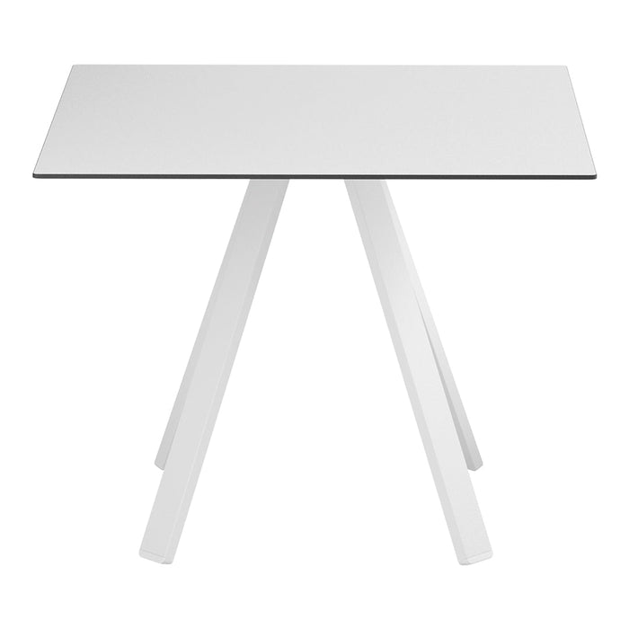Minimalist white table with sleek design and smooth surface, featuring angular white legs for a modern look.