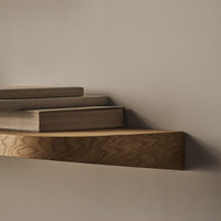 Wooden shelves in warm tones of beige and brown, featuring a smooth, natural wood grain pattern against a neutral wall.