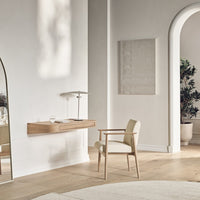 Minimalist beige chair against a light wood wall desk, featuring neutral tones and soft textures in a serene setting.