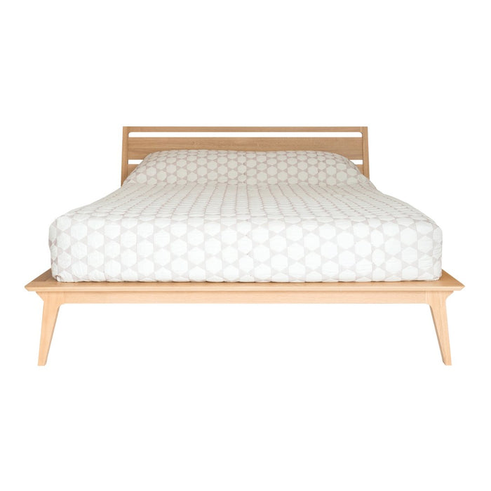 White patterned mattress with subtle circular designs on a natural wood platform bed. Simple and modern aesthetic.