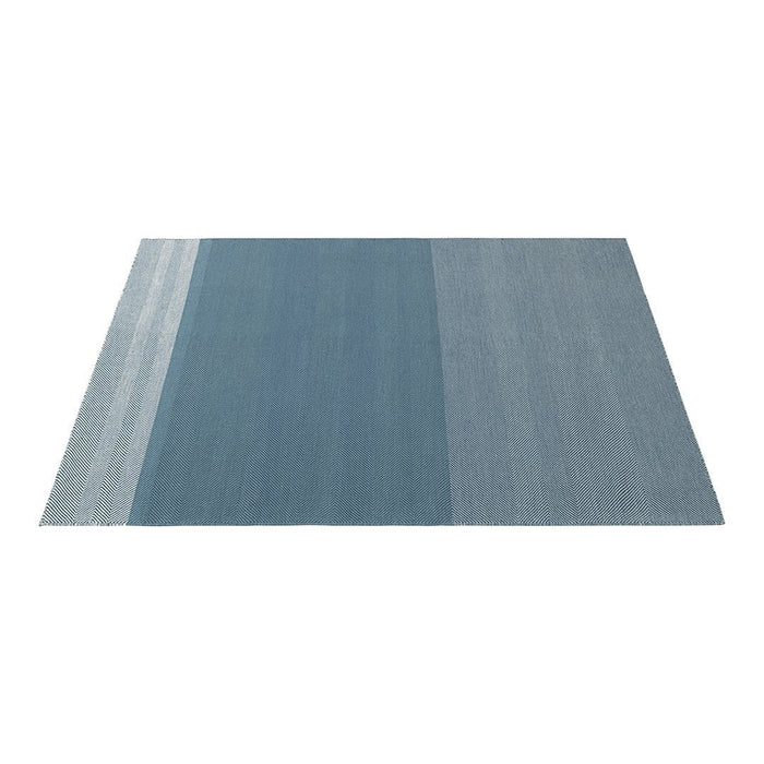 Blue gradient area rug with varying shades, featuring soft, subtle patterns and a modern design.