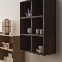 Dark wood shelving unit with clean lines, showcasing white and clear glass dishes against a neutral backdrop.