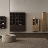 Modern wooden storage units in dark brown and light beige, with a soft textured rug and minimalist design.